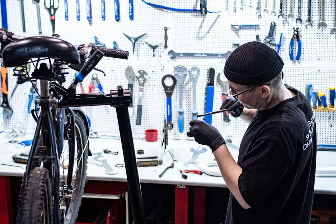 Mécanicien en train de réparer un vélo sur un établi d'atelier équipé d'outils spécialisés